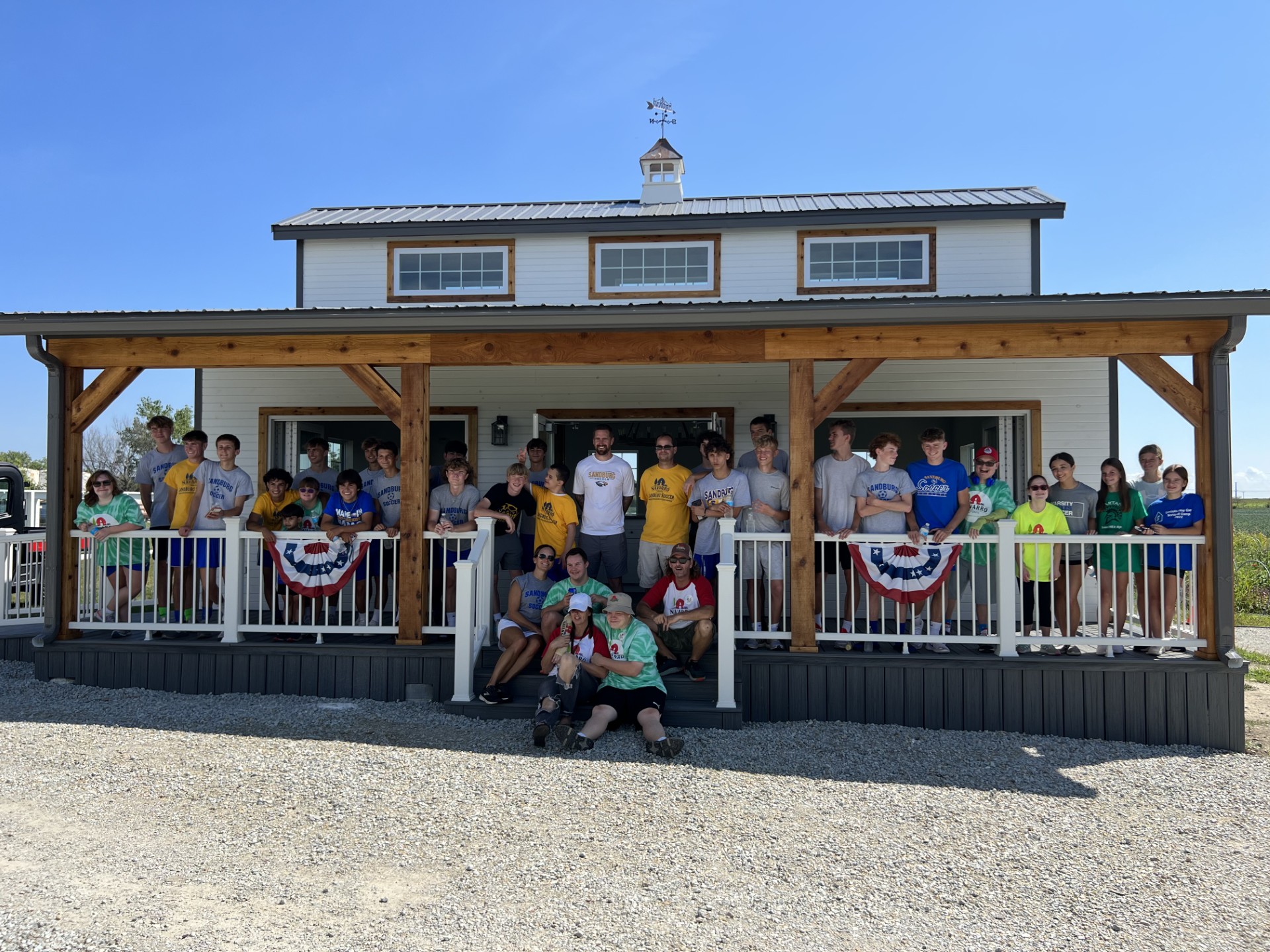 Large group of volunteers in front of farm building